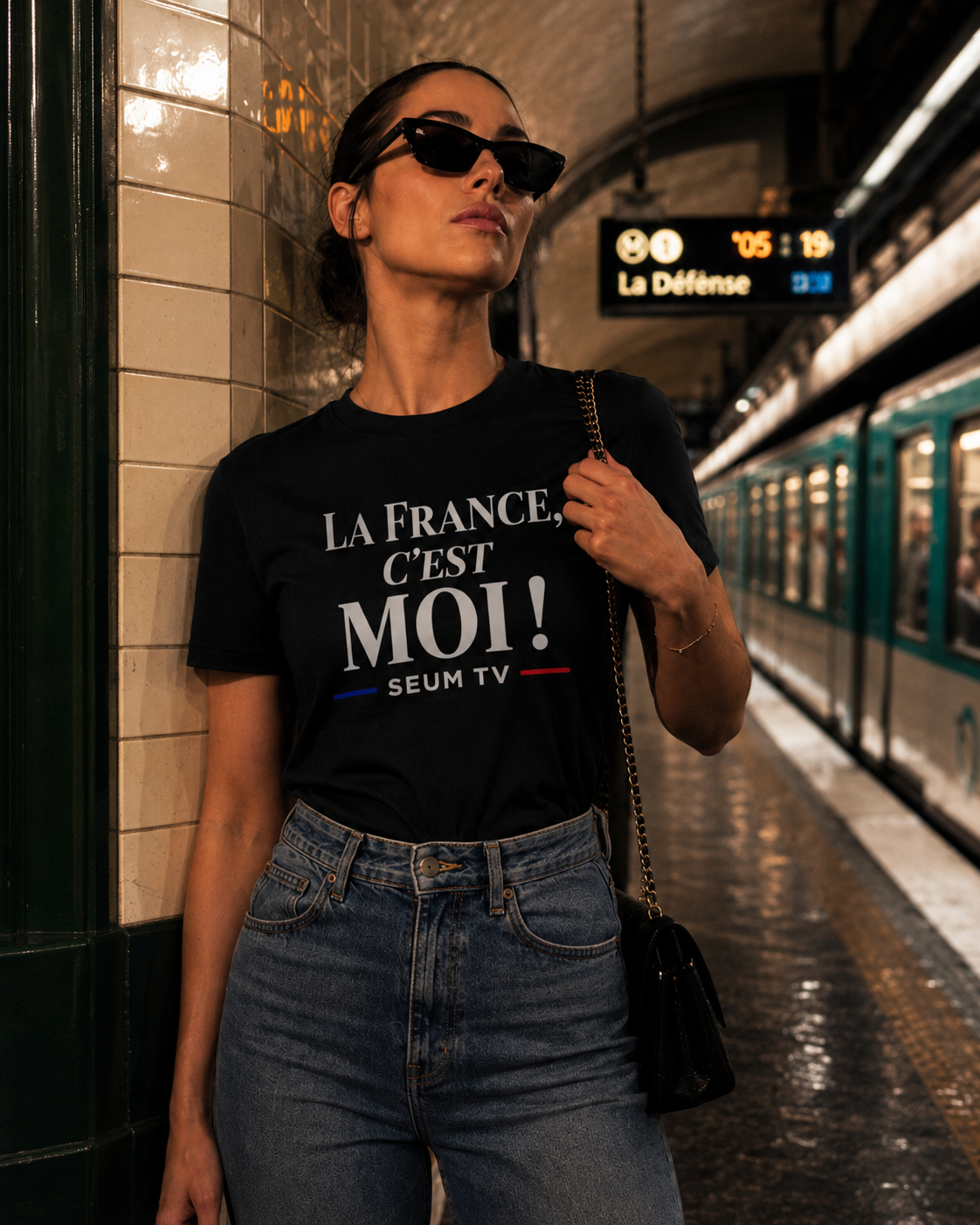 Femme portant le maillot noir “La France, c’est moi !” SEUM TV dans une station de métro parisienne.